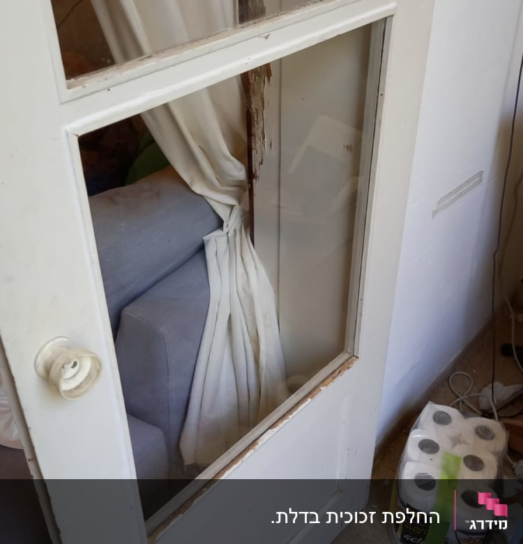 דלת עם זכוכית שבורה וחלון וילון